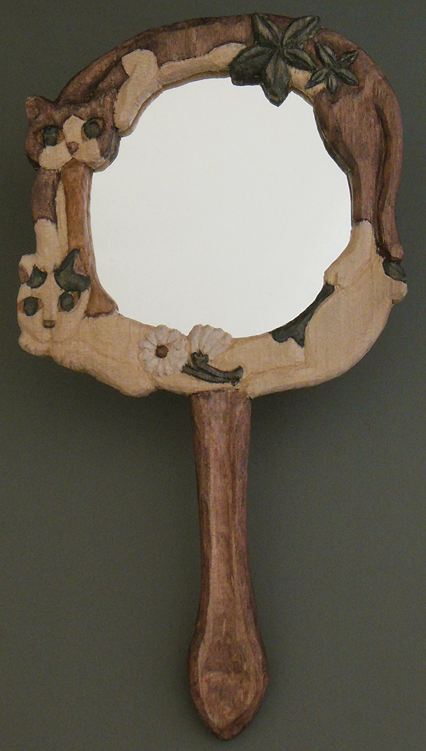 周囲に猫が彫り込まれた手鏡。上にしじみ、下にうめ