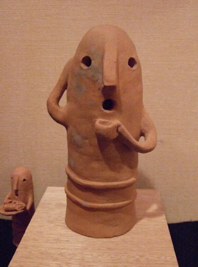 前から見た図。白木で作った機械。透明なビー玉が段々上がって行き、後ろの滑り台を降り元に戻る