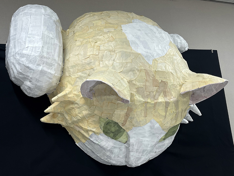 壁の上から出てこようとする巨大猫（左から）